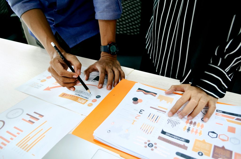 People huddling and discussing around market data